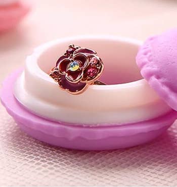 Ring with floral design displayed on a macaron jewelry holder