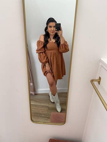 Reviewer posing in a mirror wearing the dress in light brown