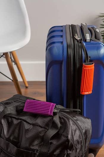 brightly colored luggage grips and luggage tags on suitcases