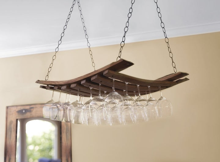 the wood panel hanging from chains and holding stemware between the slats