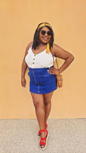a reviewer in the white tank styled with a denim skirt