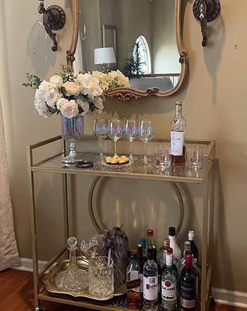 Reviewer image of the gold bar cart with bottles and glasses