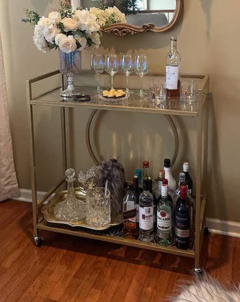 Reviewer image of the gold bar cart with bottles and glasses