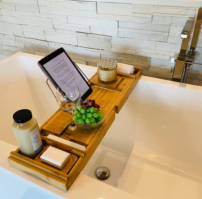 reviewer photo of natural-colored tray with candles, tablet, grapes, and wine over a tub