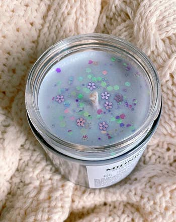 a peek inside the candle showing the lavender wax and glitter
