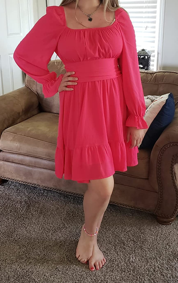 Reviewer wearing hot pink long sleeve dress with fitted bodice and balloon sleeves