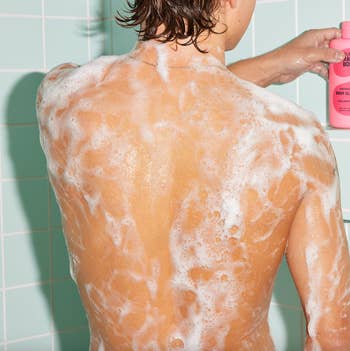 a model in the shower with a sudsy back