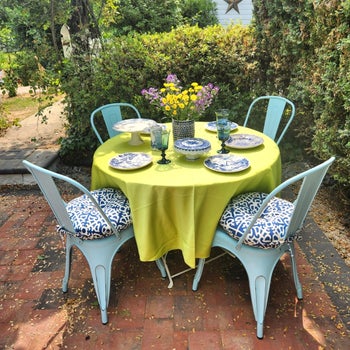 a reviewer's outdoor dining setup with tableware and flowers on garden patio table, suitable for home decor inspiration