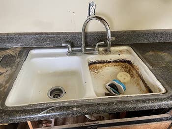 a double sink; half cleaned with pink stuff and the other half covered in dark brown and black stains