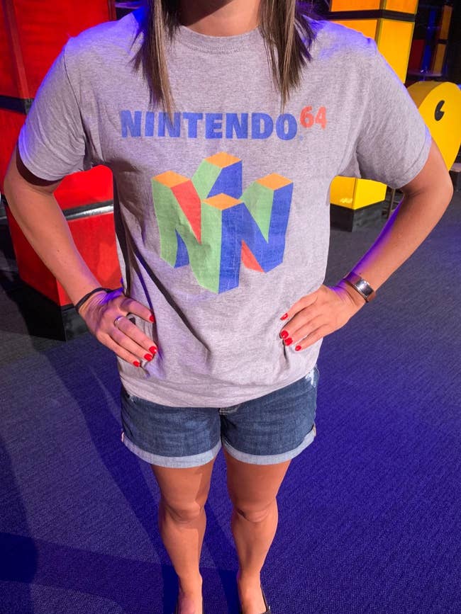 a reviewer in a gray t-shirt with the nintendo 64 logo on it