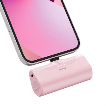 cordless portable charger in pink in a phone charger port