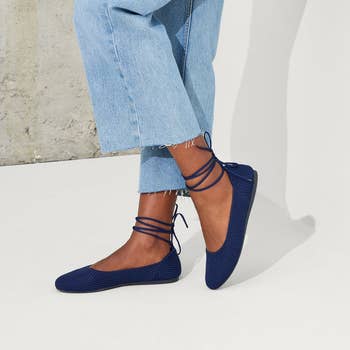 Close-up of shoes with crisscross laces wrapped around the ankles, paired with frayed jeans