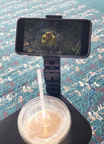 reviewer's phone displaying Shrek film while attached to mount stand