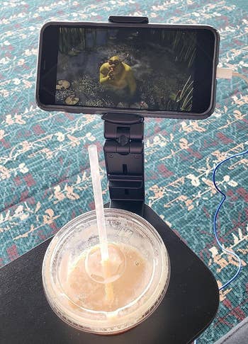 reviewer's phone displaying Shrek film while attached to mount stand