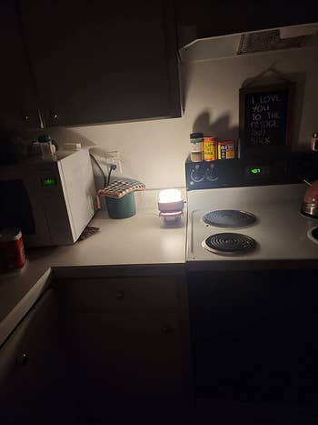 a kitchen lit up by the toaster lamp at night