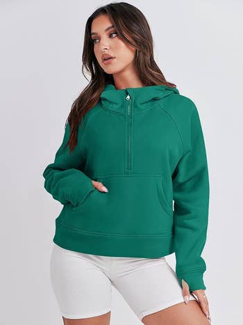 Woman in a plain green hoodie and white shorts