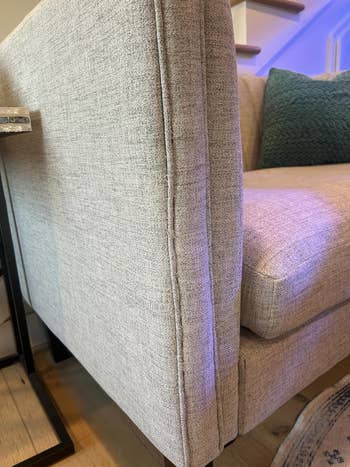 Elegant modern   grey  sofa with a textured decorativeness  successful  a cozy surviving  country   setting, accompanied by a acheronian  greenish  cushion connected  the seat