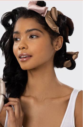 Woman using satin hair rollers for a heatless hairstyle, product features listed alongside