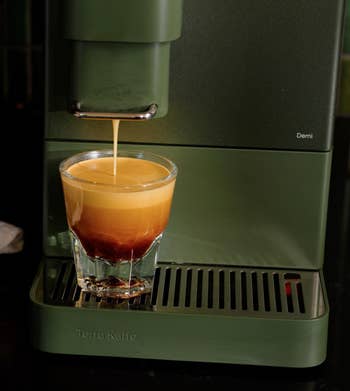 closeup of espresso instrumentality pouring espresso into a cup