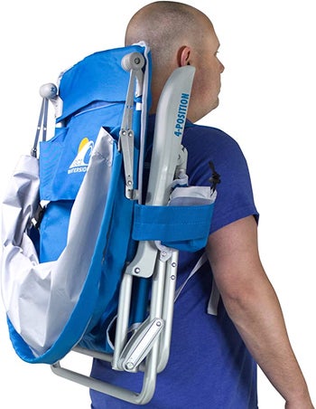 model carrying the blue beach chair as a backpack