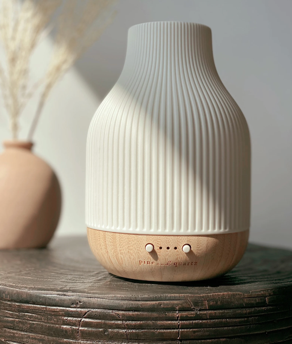 the ceramic and bamboo diffuser on a dark, wooden table