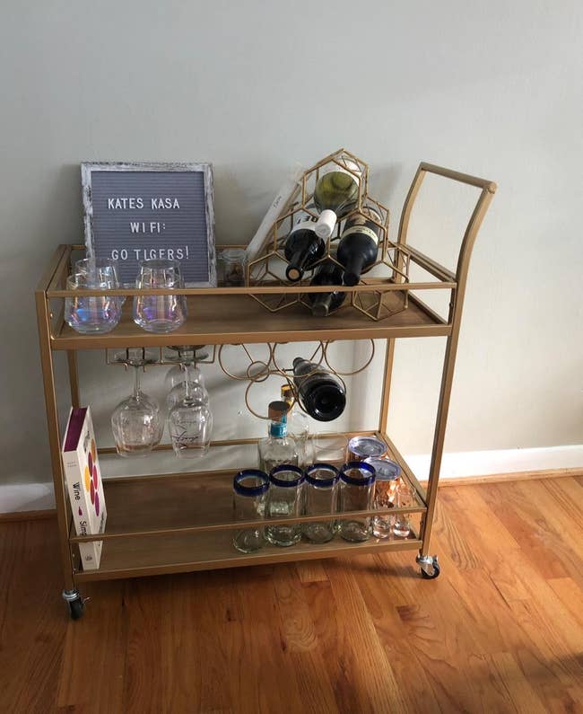 reviewer image of the gold-colored bar cart with alcohol on both tiers