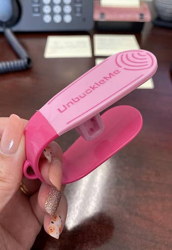a reviewer holding the tool in pink 
