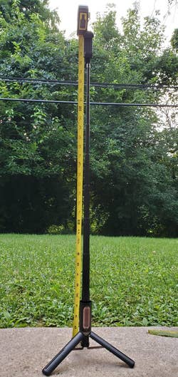 A tall, adjustable measuring stick stands on a tripod