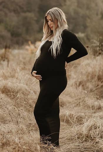 a pregnant reviewer wearing the dress in black 