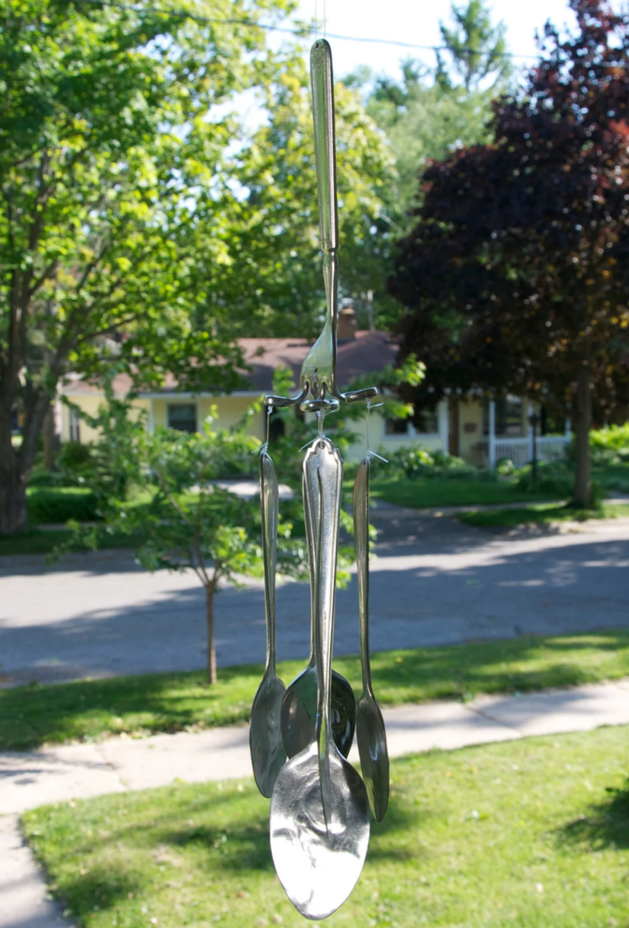 A wind chime made out of four silver spoons and one fork
