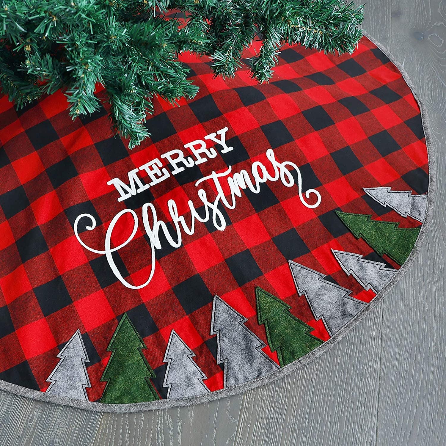 a red and black plaid tree skirt with gray and green trees along the bottom and 