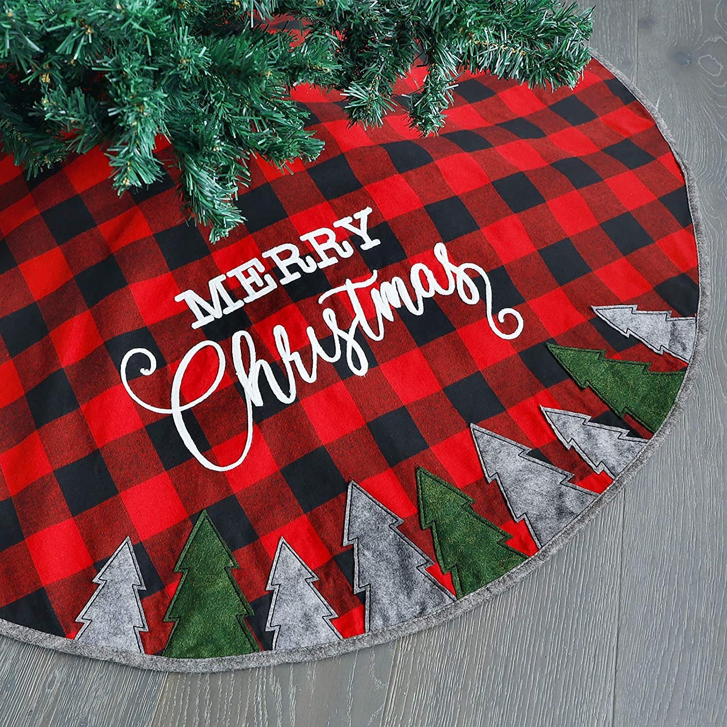 a red and black plaid tree skirt with gray and green trees along the bottom and