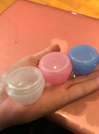 Reviewer holding the smaller containers in their hand to show size