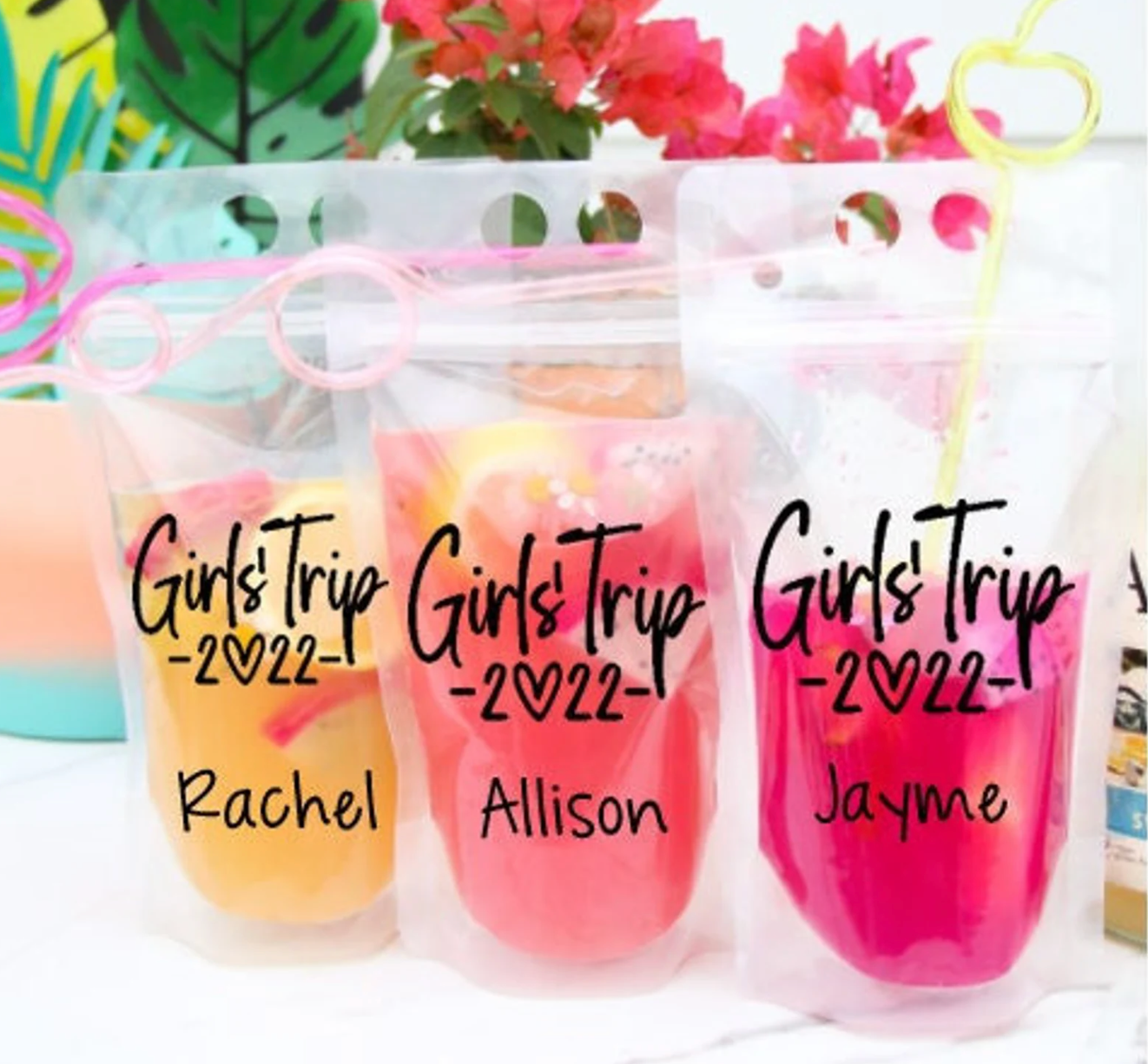 three clear pouches with drinks in them personalized with names on and a girl's trip for 2022 