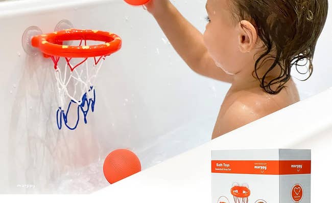 a child playing with a basketball hoop in the tub