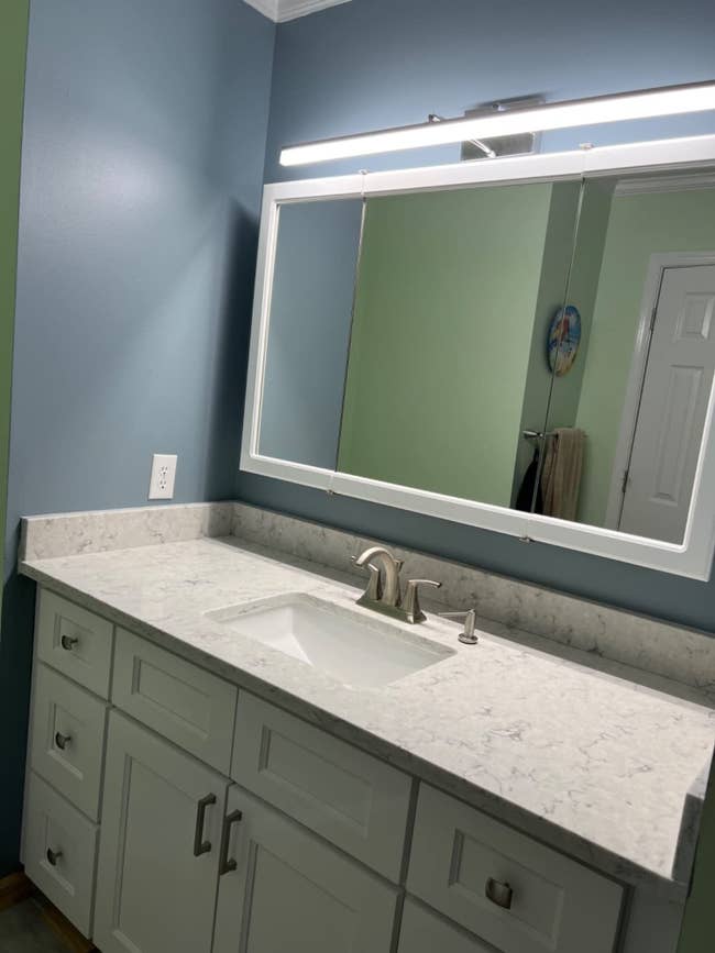a light fixture over a bathroom mirror and sink