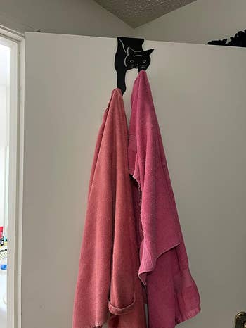 the black cat coat hook holding towels