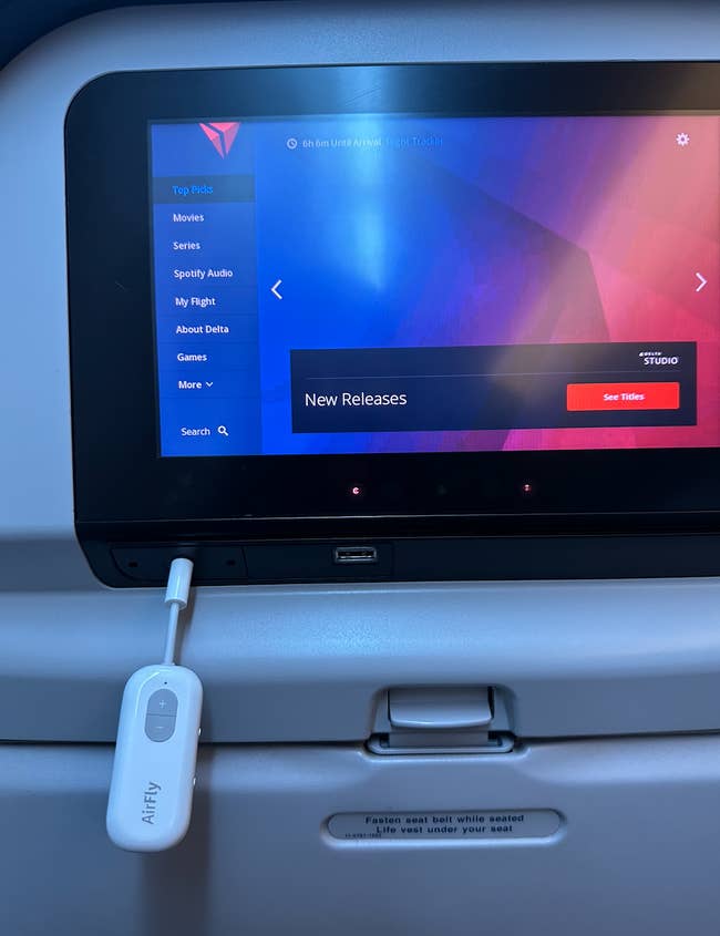 BuzzFeed writer's AirFly plugged in to the TV on an airplane