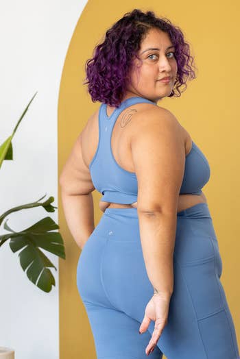 model in a blue sports bra showing the racer back details