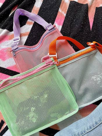 reviewer's three mesh bags in pale green, blue, and pink 