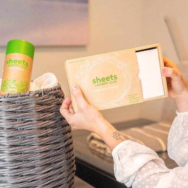 Model holding small box of detergent sheets 