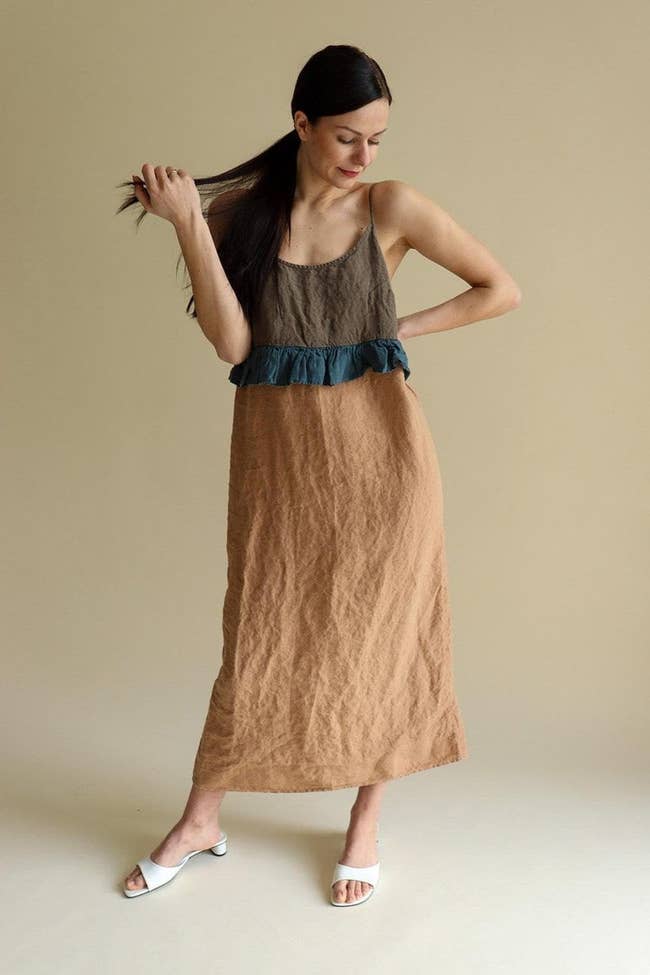 model in the dark brown, teal, and tan colorblocked slip with ruffle at waist