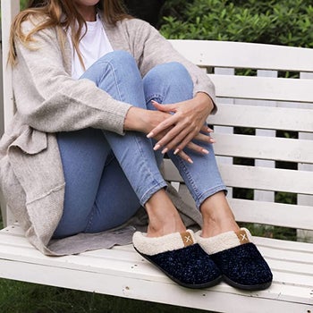model wearing the black and blue slippers