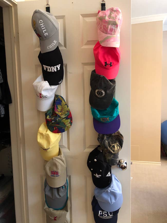reviewers organizer installed on the back of a door holding two rows of hats