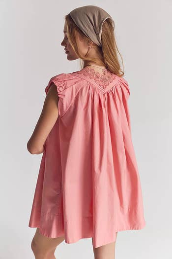Model in a flowy, embroidered dress and headscarf, showcasing breathable, lightweight fashion suitable for warm weather