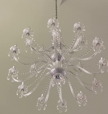 after photo of the same chandelier looking brighter and cleaner