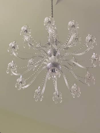 after photo of the same chandelier looking brighter and cleaner