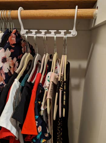 a reviewer photo of the wonder hanger with clothes loaded on it 