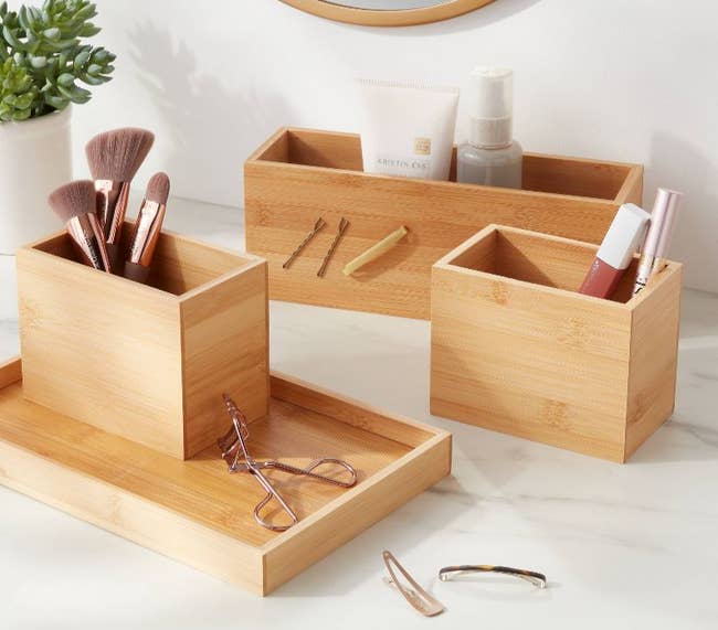 the wooden organizer holding makeup brushes, lotion bottles, and bobby pins