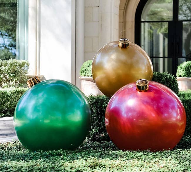 a red, a green, and a gold oversized ornament